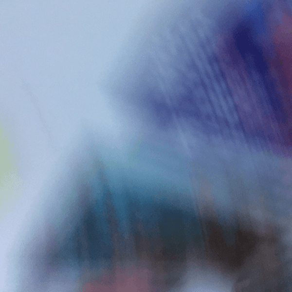 Une photo complètement floue. Les couleurs vont du vert au bleu et donnent un sentiment de mouvement.